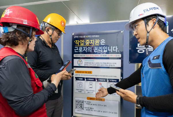 DL이앤씨 현장 안전관리자(우측 첫번째)가 현장 근로자들에게 안전신문고 접속 및 작업중지권 사용법에 대해 설명하고 있다. [DL이앤씨 제공=뉴스퀘스트]