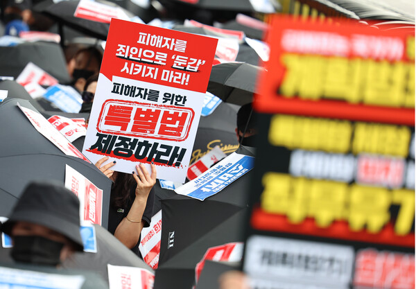 21일 정부는 경제관계장관회의를 열고, ‘위메프·티몬 사태 대응 방안 추진 상황 및 향후 계획’을 통해 1조 6000억원 규모의 자금 지원을 추진한다고 밝혔다.  티몬·위메프 피해 판매자와 소비자들이 최근 서울 종로구 금융위원회 앞에서 '검은 우산 집회'를 열고 피해자 구제를 위한 특별법 제정을 촉구하고 있는 모습. [사진=연합뉴스]