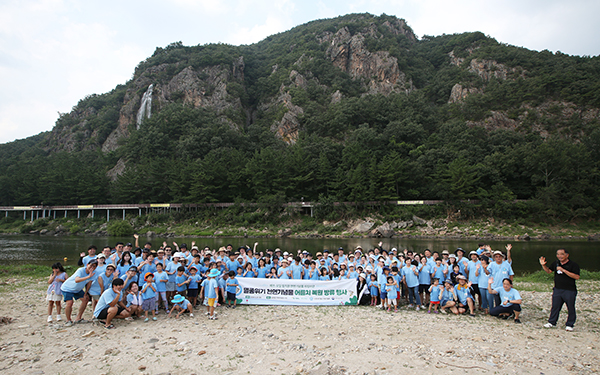 천연기념물 어름치 치어 방류 봉사활동에  참여한 에쓰오일 직원 가족과 한국민물고기보존협회 및 환경재단 관계자들이 기념촬영을 하고 있다. [사진=에쓰오일]