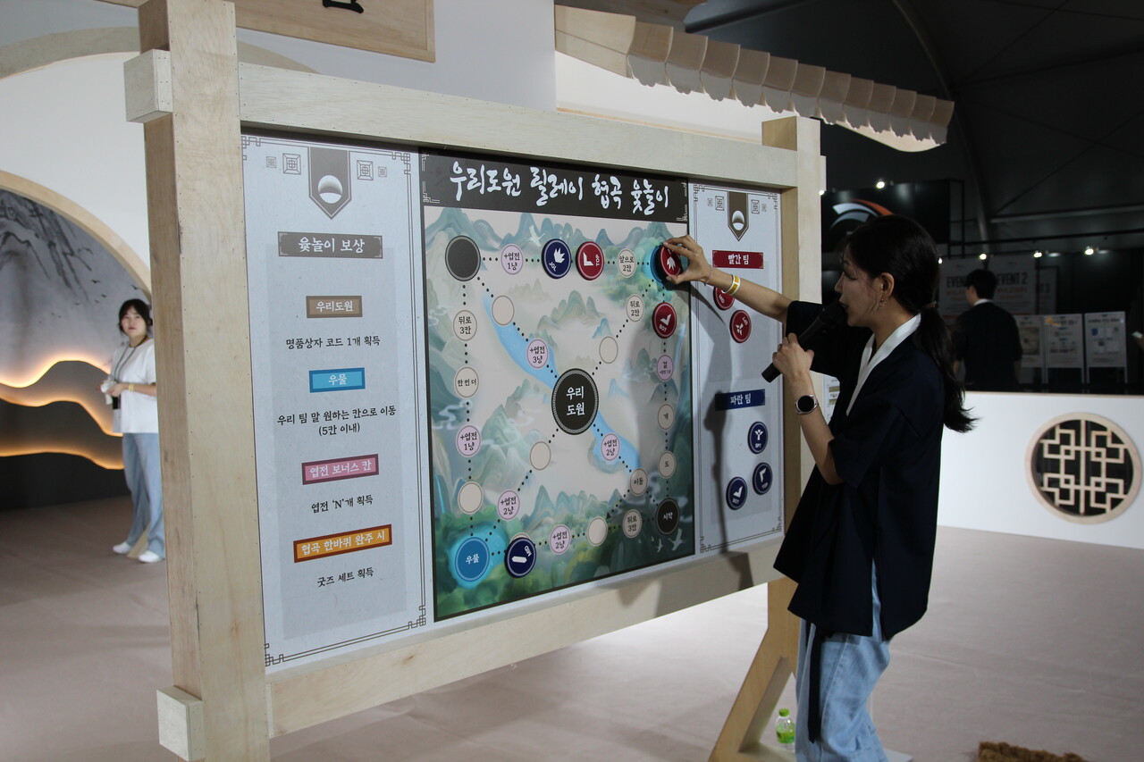 우리은행 '팬페스타' 부스 담당자가 '협곡 윷놀이'를 설명하고 있다. [사진=김민우 기자]