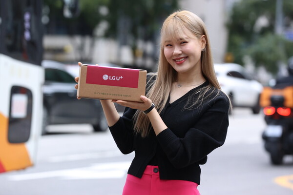 방송인 엄지윤이 유플러스닷컴 사전예약 고객인 김민선씨에게 '아침배송'으로 아이폰16 프로를 전달하는 모습.