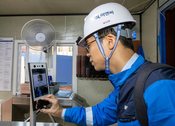 DL이앤씨 근로자가 안전삐삐를 지급받은 후 안면인식 시스템을 거쳐 현장에 출입하고 있다. [DL이앤씨 제공=뉴스퀘스트]