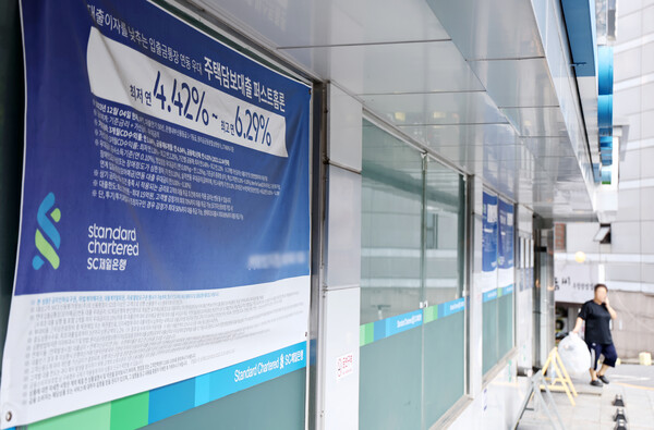 한국은행 금융통화위원회가 11일 기준금리를 0.25%포인트 낮췄지만, 금융권은 가계부채와 부동산 불안정성 등을 근거로 시중은행 대출금리가 빠르게 조정되지는 않을 것이라는 전망을 내놓고 있다.  서울의 한 은행에 붙은 대출 관련 정보. [사진=연합뉴스]