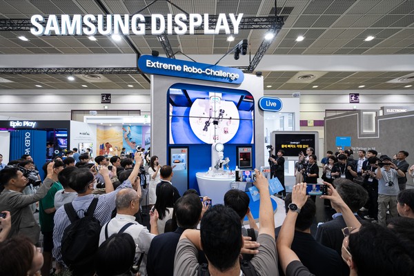 삼성디스플레이가 대만의 수도 타이베이시에 위치한 그랜드메이풀 호텔에서 '삼성 OLED IT 서밋 2024'를 개최했다. 사진은 지난 8월 열린 'K-디스플레이 2024'에 참가한 삼성디스플레이 부스에서 관람객들이 폴더블 내구성을 테스트하는 로봇쇼를 관람하는 모습. [삼성디스플레이 제공=뉴스퀘스트]