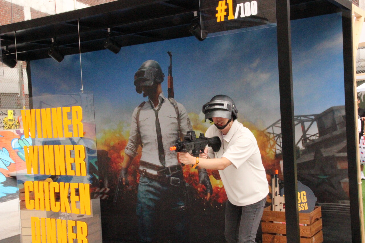 한 남성 관람객이 게임 내에서 일명 '뚝배기'로 불리는 헬멧 아이템을 착용한 채 사진을 찍고 있다. [사진=김민우 기자]