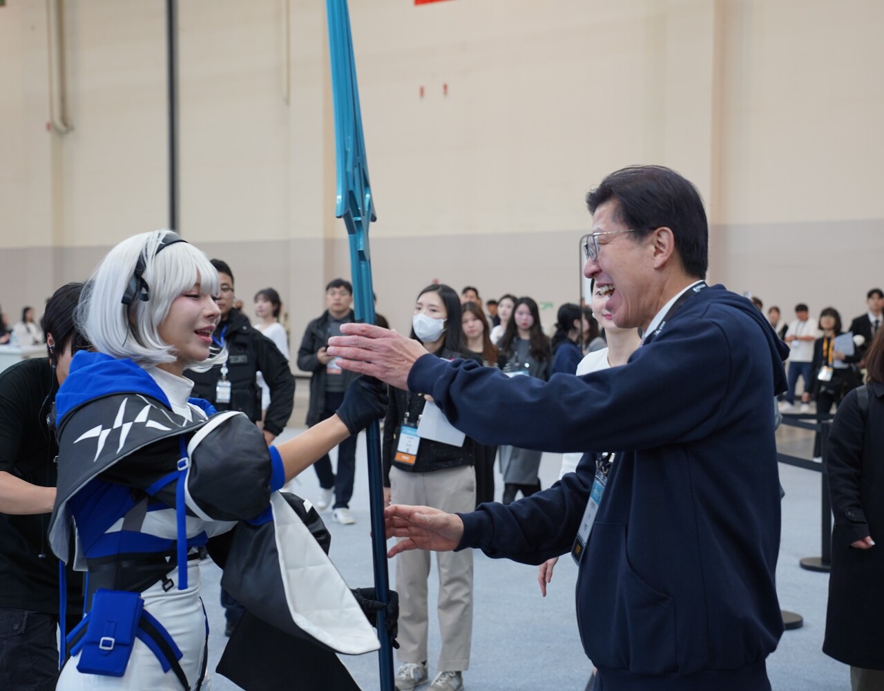 박형준(사진 오른쪽) 부산시장이 웹젠 부스에서 파란 깃창 아이템을 전달받고 있다. [사진=김민우 기자]