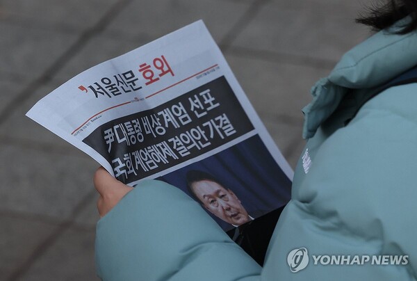 윤석열 대통령이 긴급 대국민 담화를 통해 비상계엄 해제를 선언한 4일 오전 서울 종로구 종각역 인근에서 시민들이 관련 내용이 적힌 호외를 들고 이동하고 있다. [사진=연합뉴스]