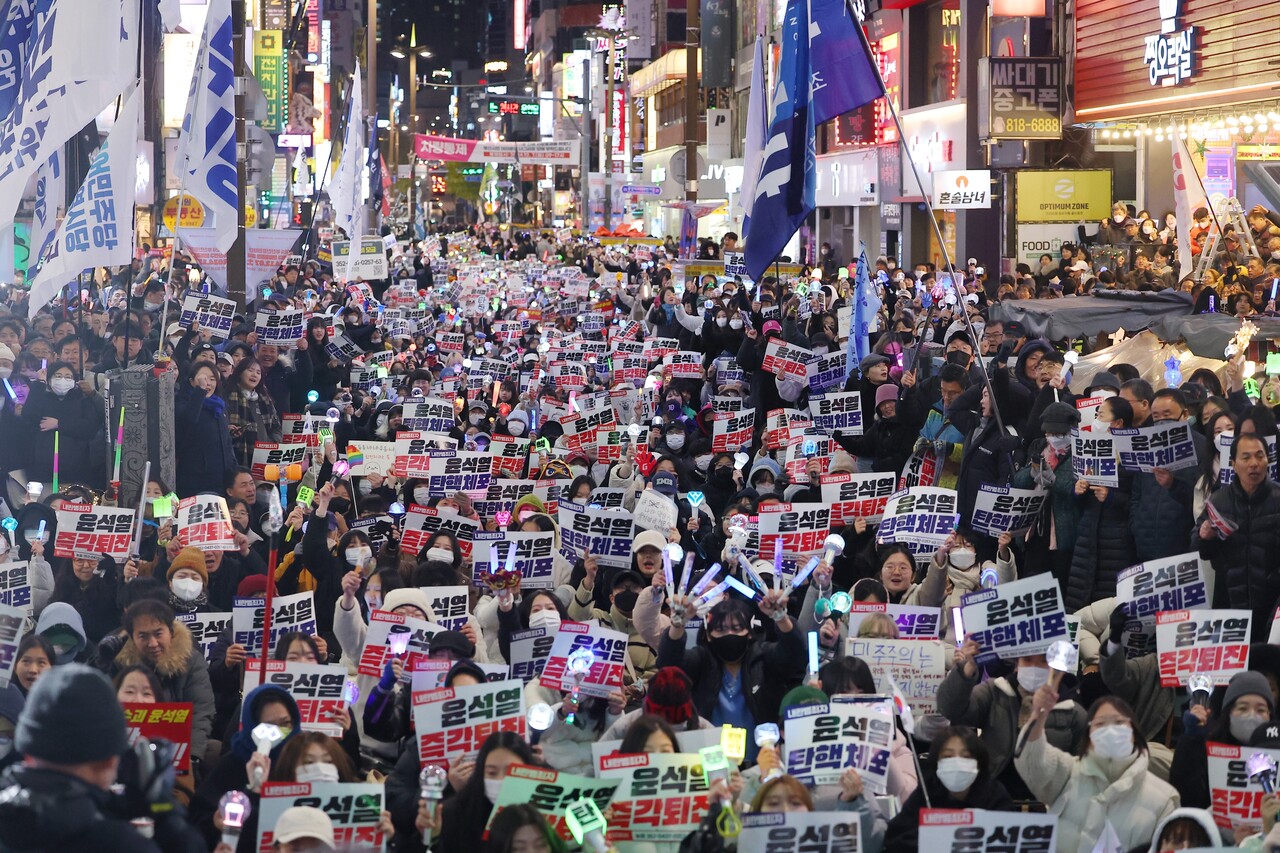 권구훈 골드만삭스 선임이코노미스트는 9일 '짧은 계엄령 사태의 여파'라는 제목의 보고서를 통해 "내년 한국 성장률 전망치를 시장 평균보다 낮은 1.8%로 유지하지만 리스크는 점점 더 하방으로 치우치고 있다"고 밝혔다. 지난 8일 오후 부산 서면 젊음의거리 일대에서 열린 윤석열즉각퇴진부산시민대회에서 참가자들이 구호를 외치고 있는 모습. [사진=연합뉴스]  