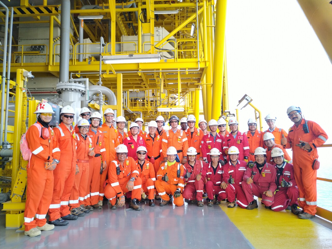 한화오션 및 NOC 관계자들이 알샤힌(Al-Shaheen) 유전 지역에 설치된 고정식 원유생산설비에서 기념촬영을 하고 있다. [한화오션 제공=뉴스퀘스트]