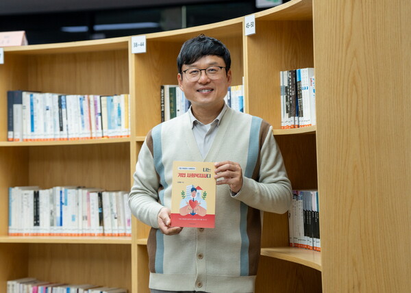 S-OIL 신영철 사회복지사가 최근 발간한 ‘나는 기업 사회복지사다’ 책을 들고 기념촬영을 하고 있다. [사진=S-OIL]