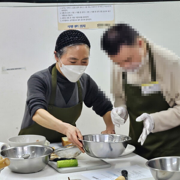 서울노인복지센터의 어르신 요리 강사가 장애인에게 요리법을 알려주고 있다. [사진=서울노인복지센터]