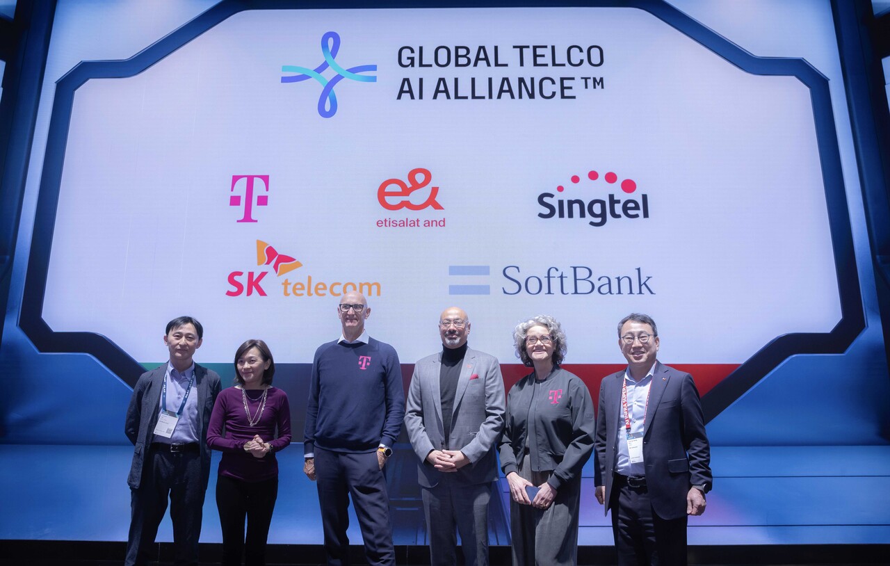 (사진 왼쪽부터) 타다시 이이다(Tadashi Iida) 소프트뱅크 최고정보보안책임자(CISO), 아나 입(Anna Yip) 싱텔 그룹 인터내셔널 디지털 서비스 CEO, 팀 회트게스(Tim Höttges) 도이치텔레콤 회장, 하템 도비다(Hatem Dowidar) 이앤(e&) 그룹 CEO, 클라우디아 네맛(Claudia Nemat) 도이치텔레콤 기술혁신담당이사, 유영상 SKT CEO가 지난 3일 MWC25에서 글로벌 텔코 AI 얼라이언스 로고를 배경으로 최고 경영진이 기념 사진을 촬영하고 있다. [사진=SKT]