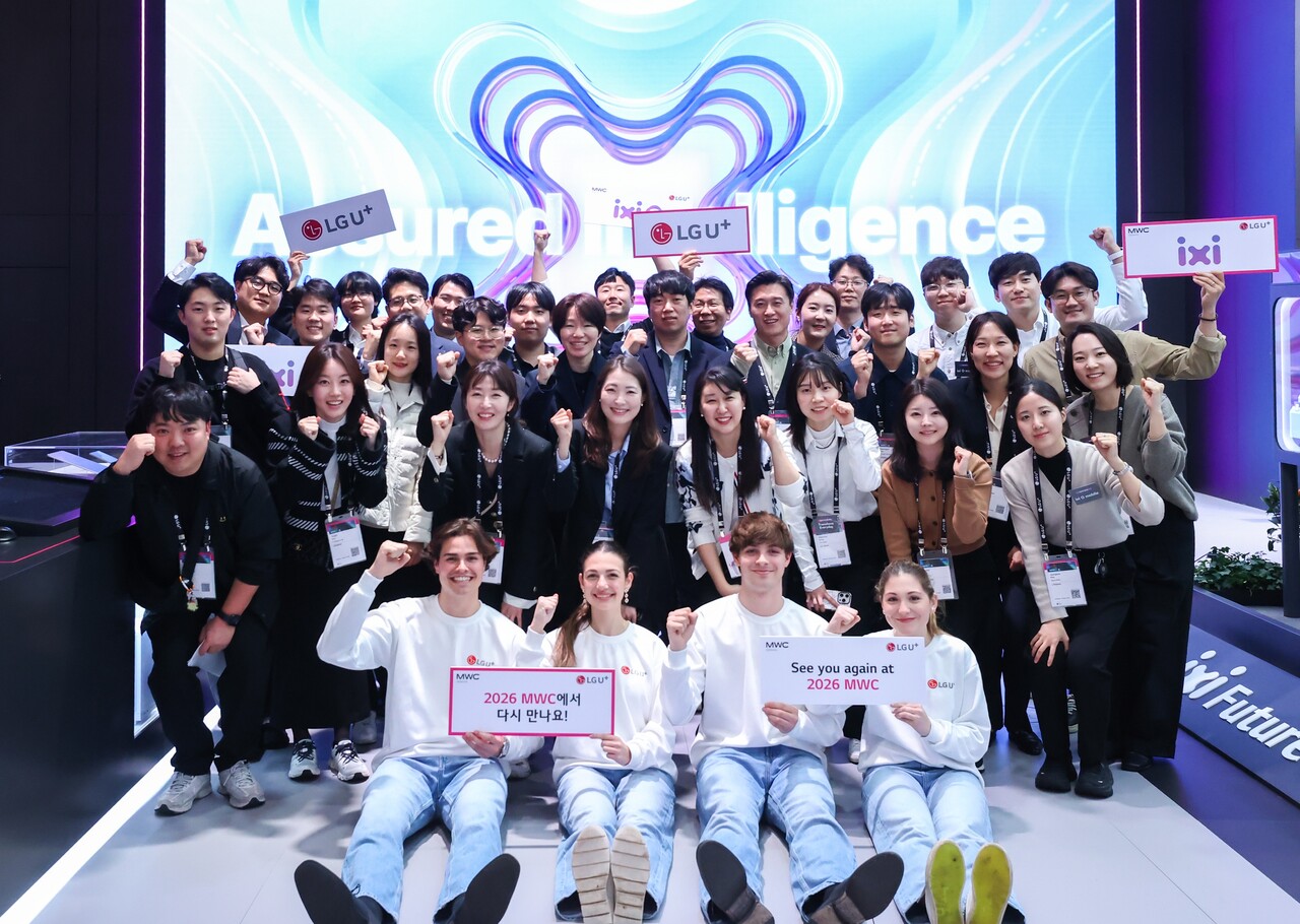 LG유플러스 MWC25 전시관에서 임직원들이 내년 MWC에 대한 기대감을 드러내는 사진을 촬영하고 있다. [사진=LGU+]