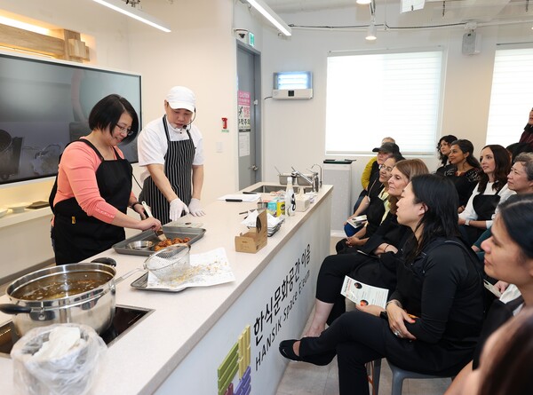 ‘교촌1991스쿨’ 프로그램 현장에서 참가 외국인들이 조리 모습을 지켜보고 있다. [사진=교촌치킨 제공]