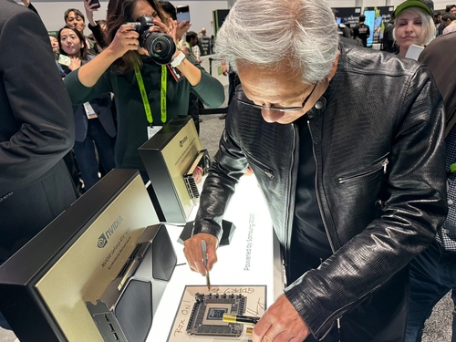 젠슨 황 엔비디아 최고경영자(CEO)가 연례 개발자 콘퍼런스 GTC 2025 넷째 날인 20일(현지시간) 삼성전자 부스를 찾아 그래픽 메모리에 친필 사인을 하고 있다. [사진=연합뉴스]