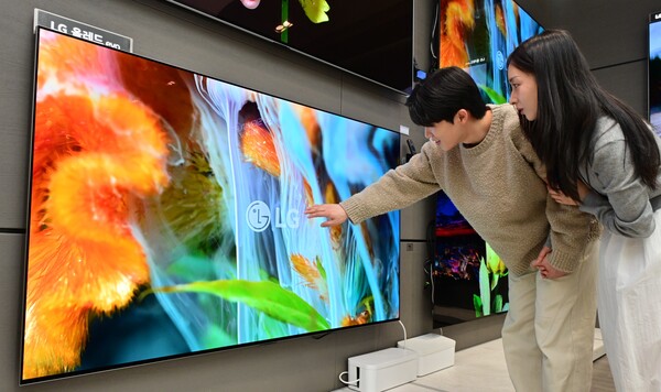 LG전자 모델이 최대 밝기가 일반형(B5) 대비 3배에 이르는 올레드 에보 신제품의 생동감 넘치는 영상을 감상하고 있다. [사진=LG전자]