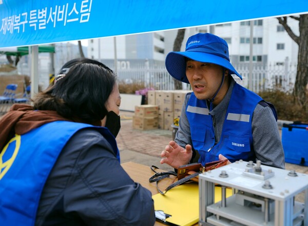 삼성전자서비스 재난복구특별서비스팀 직원이 지난달 28일 경북 의성 실내체육관에 마련된 이재민 대피소에서 산불 피해 주민과 가전제품 수리 상담을 진행하고 있다. [사진=삼성전자서비스]