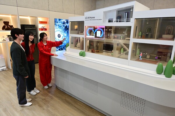 LG전자가 월드IT 쇼 2025에 참가했다. 모델이 미니어처 모형 집과 투명 올레드로 만들어진 디오라마를 통해 표현한 'AI홈'을 체험하고 있다. [사진=LG전자]