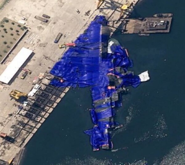 지난 21일 함북 청진하에서 진수식 도중 미끄러져 바다에 들어누워 버린 북한 신형 구축함. 현장에서 이를 지켜본 김정은 국무위원장은 관련자 문책을 지시하는 등 격앙된 반응을 보이고 있다. [사진=비욘드 패럴렐]