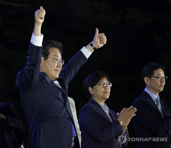 제21대 대통령 당선이 확실시되는 더불어민주당 이재명 대선 후보가 4일 서울 여의도 국회 인근에서 당 주최로 열린 국민개표방송 행사에 참석해 시민들을 향해 두 팔을 들어 인사하고 있다. [공동취재]