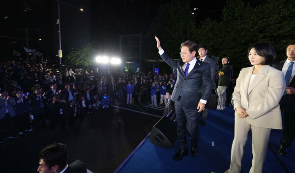 4일 밤 제21대 대통령 당선이 확실시되는 더불어민주당 이재명 대선 후보와 부인 김혜경 여사가 서울 여의도 국회 인근에서 당 주최로 열린 국민개표방송 행사에 참석해 시민들을 향해 손들어 인사하고 있다. [사진=연합뉴스]