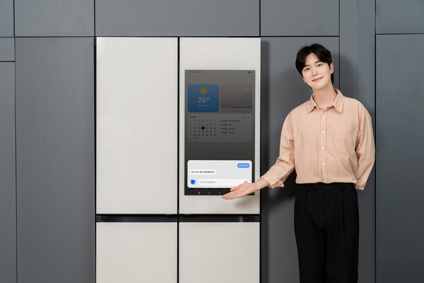 터치 스크린이 탑재된 비스포크 AI 냉장고 앞에서 모델이 보이스 ID 기능을 소개하고 있다. [사진=삼성전자]