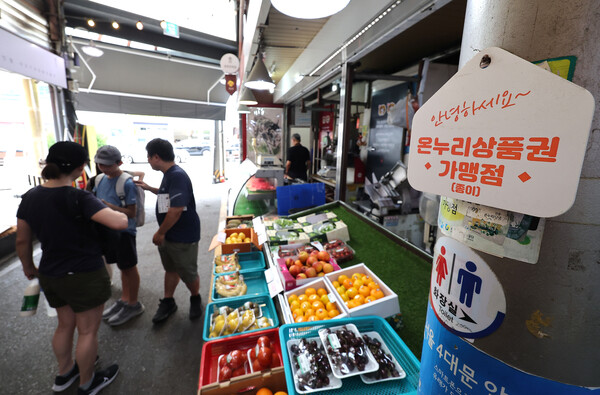 최근 행정안전부는 카드사들에게 민생회복 소비쿠폰 결제 시 가맹점 수수료를 낮추는 방안을 검토해줄 것을 요청한 것으로 알려졌다. 서울의 한 전통시장 점포에 기존 골목경제 소비 활성화를 위한 온누리상품권 가맹 팻말이 붙어 있다. [사진=연합뉴스]