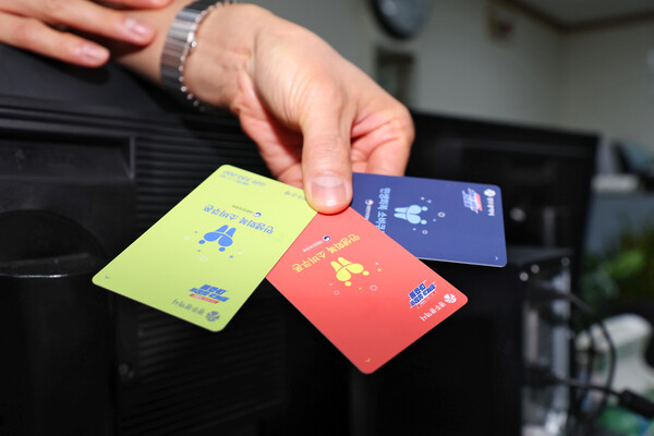 민생회복 소비쿠폰 지급 사흘째인 23일 오후 광주 서구 농성1동 행정복지센터에서 한 직원이 서로 다른 색상의 현물 카드를 들고 있다. [사진=연합뉴스]