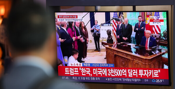 지난달 31일 한국과 미국의 관세 협상이 타결됐을 당시서울역 대합실에서 한 시민이 관련 뉴스를 시청하고 있다. [사진=연합뉴스]