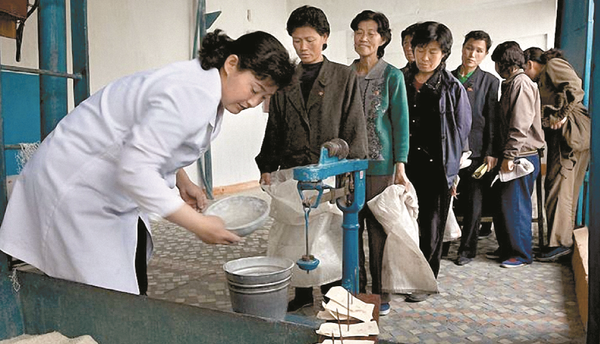 북한의 한 식량 배급소에서 주민들이 줄서서 차례를 기다리고 있다. [사진=연합]