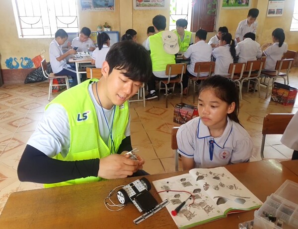 이달 초 LS 대학생 해외봉사단 28기 단원들이 베트남 팜타이 초등학교에서 학생들을 대상으로 과학키트 만들기 체험학습을 진행하고 있다. [사진=LS그룹]