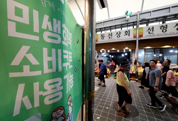 소상공인연합회는 전국상인연합회와 이달 5∼7일 골목상권과 전통시장 소상공인 2035명을 대상으로 소비쿠폰 관련 온라인 설문조사를 해보니 응답자의 55.8%가 소비쿠폰 사용 이후 사업장에서 매출이 늘었다고 답했다고 12일 밝혔다. 서울 동대문구 청량리종합시장에 민생회복 소비쿠폰 관련 안내문이 붙어 있다. [사진=연합뉴스] 