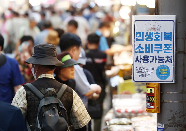 기획재정부는 ‘최근 경제동향’(그린북) 8월호를 내고, “최근 한국 경제는 건설투자 회복 지연, 취약부문 중심 고용 애로, 미국 관세 부과에 따른 수출 둔화 우려가 지속되고 있다”고 14일 밝혔다.  민생회복 소비쿠폰 지급 후 첫 주말인 지난달 27일 서울 동대문구 청량리종합시장 한 가게에 쿠폰 사용이 가능하다는 안내문이 붙어 있다. [사진=연합뉴스]