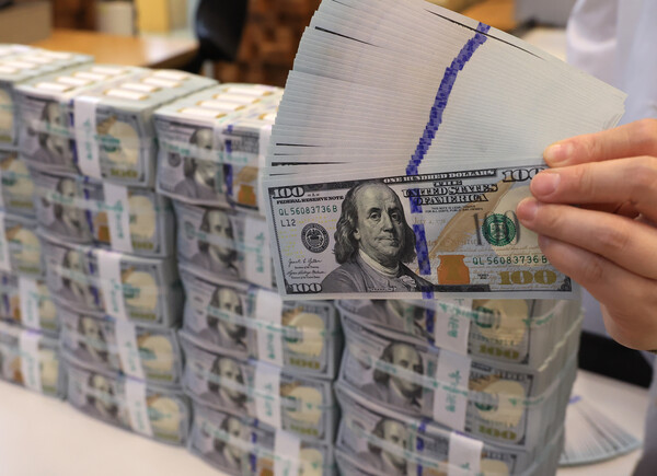 한국예탁결제원에 따르면 국내 투자자는 7월 1일부터 9월 3일까지 미국 주식을 17억8000만 달러(한화 약 2조4641억원) 순매수 결제한 것으로 집계됐다. 서울 명동 하나은행 위변조대응센터에서 직원이 미국 달러를 들어보이고 있다. [사진=연합뉴스] 
