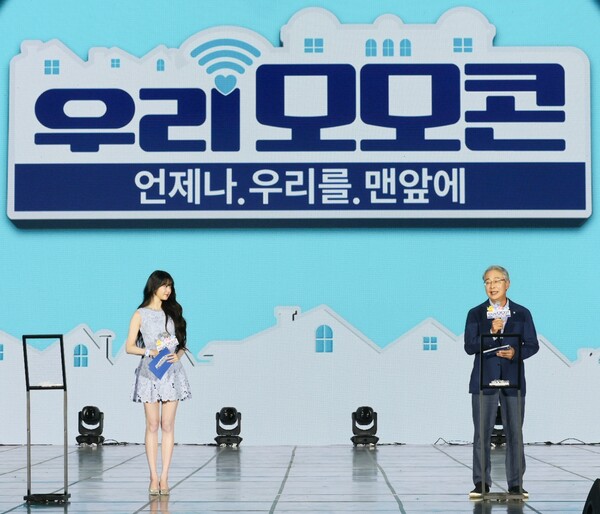 우리금융그룹은 최근 서울 난지한강공원 젊음의 광장에서 사회공헌 콘서트 ‘모이면 모일수록 선한 힘이 커지는 콘서트, 우리모모콘’을 개최했다고 22일 밝혔다. 우리은행 앰배서더 장원영과  우리금융그룹 임종룡 회장이 우리모모콘 무대에서 우리금융그룹의 사회공헌 사업을 소개하고있다. [사진=우리금융그룹]