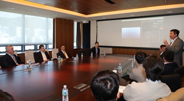 폴 르윈(Paul Lwin) 해벅AI(HavocAI) CEO(맨 오른쪽 발표자)가 한화 임직원들에게 하와이 앞 바다에 대기중인 해벅AI의 무인수상정을 한화오션 거제사업장에서 원격통제하는 기술 시연을 선보이고 있다. [사진=한화그룹]