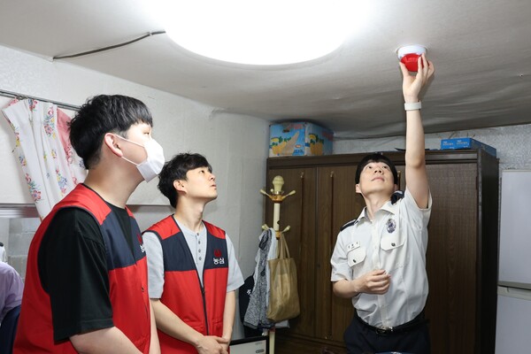 농심 '세상을 울리는 안심캠페인'의 일환으로 소방관이 취약계층 가구에 화재경보기를 설치하고 있다. [사진=농심]