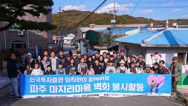 최근 한국투자증권 임직원과 가족들이 경기도 파주 마지리마을에서 벽화그리기 봉사활동을 하고 기념사진을 촬영하고 있다. [사진=한국투자증권]