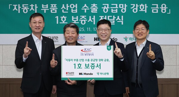 하나은행은 지난 17일 HL만도, 한국무역보험공사와 함께 『자동차 부품산업 수출 공금망 강화를 위한 금융지원』 1호 지원 기업인 (주)케이에이씨를 방문해 보증서를 전달하고 유동성 지원 등 내실 있는 금융지원을 이어가기로 했다.강원도 원주시 소재 (주)케이에이씨 반계공장에서 열린 이날 행사에 참석한 진건창 하나은행 외환사업본부장(사진 왼쪽에서 세번째)이 김성일 HL만도 부사장(사진 왼쪽에서 첫번째), 하영봉 (주)케이에이씨 대표이사(사진 왼쪽에서 두번째), 장진욱 한국무역보험공사 부사장(사진 왼쪽에서 네번째)과 기념촬영을 하고 있다.[사진=하나은행]