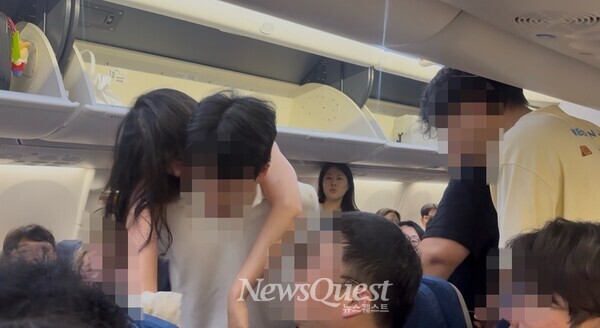 일본 다카마쓰 공항에서 에어컨 고장으로 찜통이 된 진에어 여객기 안에서 한 여성 승객이 더위를 견디지 못하고 실신해 다른 남성 승객의 등에 업혀 이동하고 있다[사진=뉴스퀘스트 이윤희 기자]